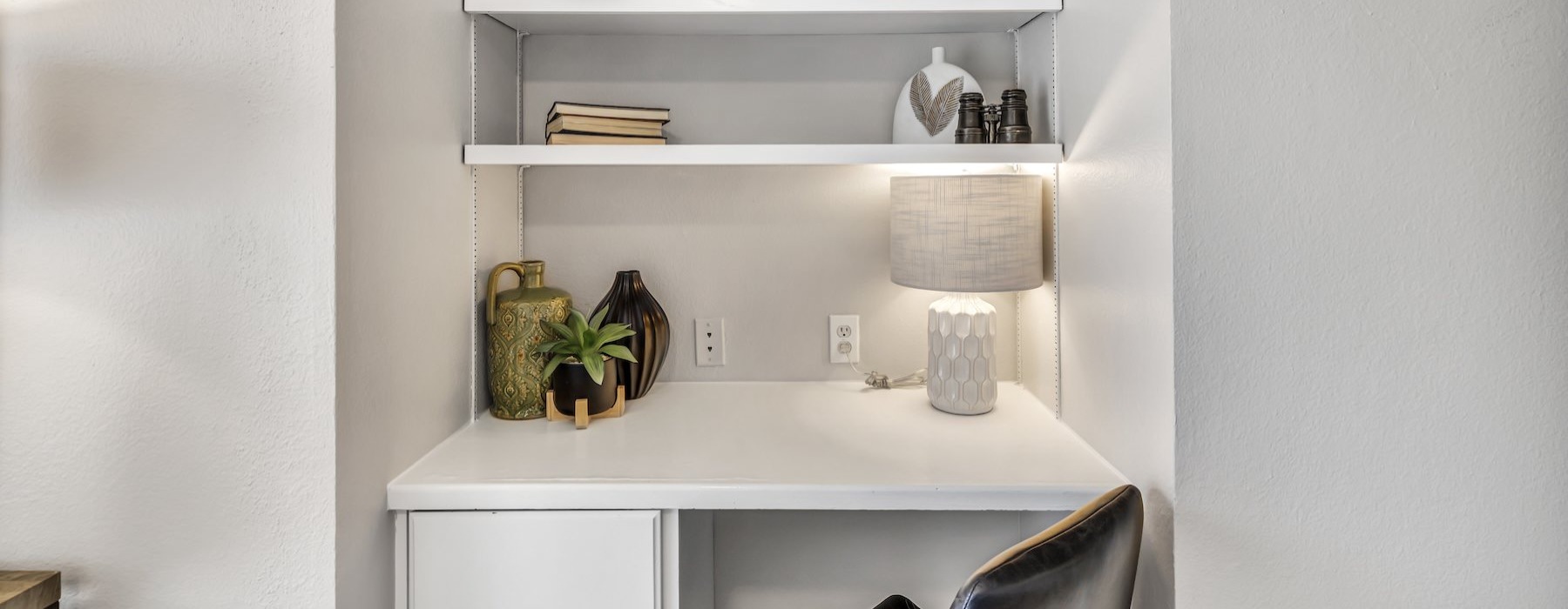 a desk area with a chair and shelves