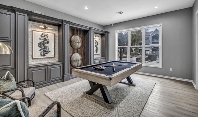a clubroom with a pool table and chairs